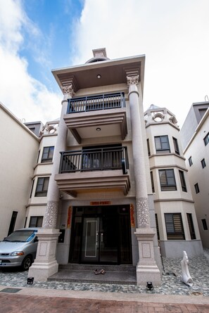A multi-story building with a central entrance, columns, and balconies. - Cattleya B&B (Magong)