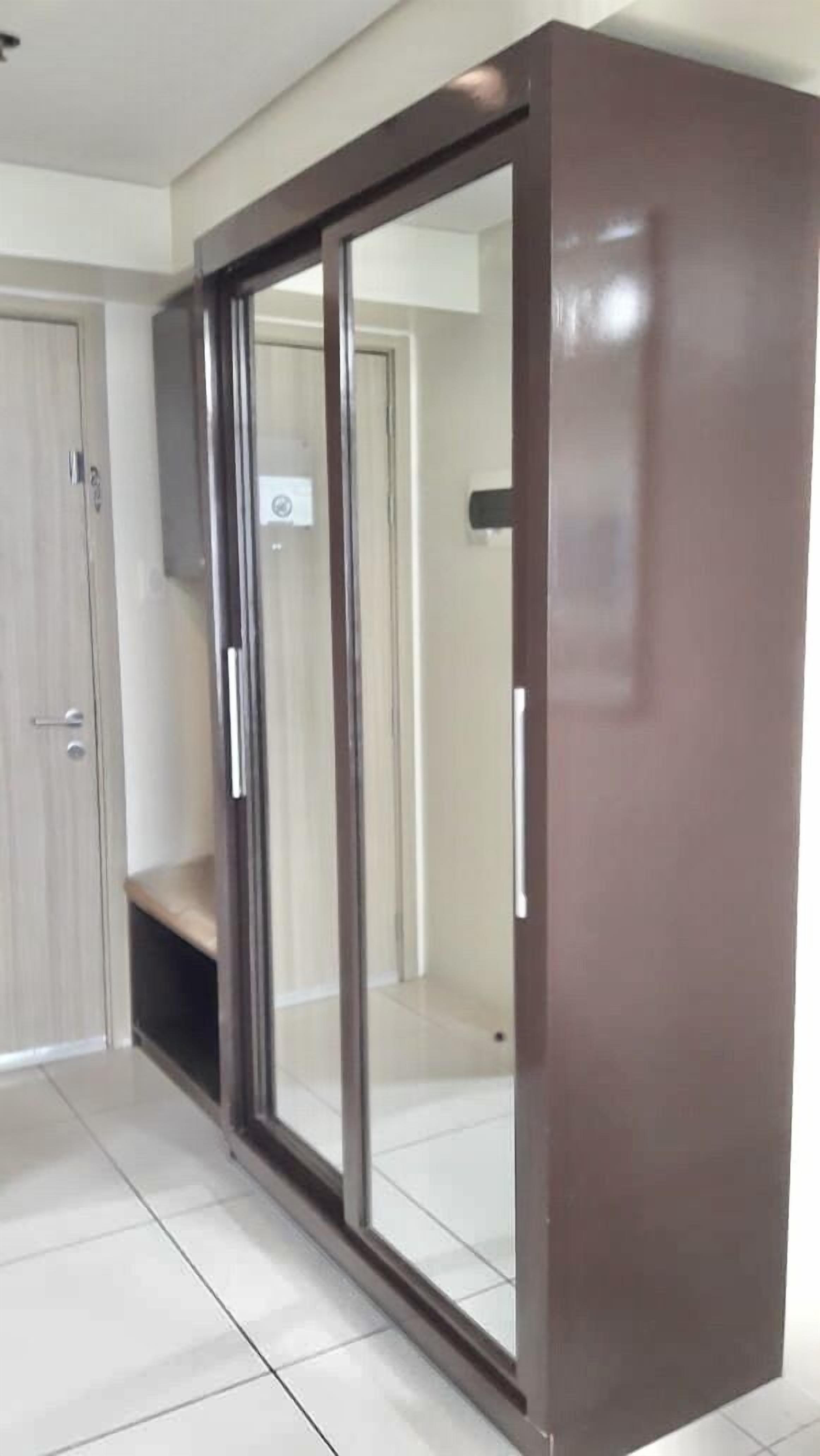 A room with a sliding glass door closet, a wooden door, and a tiled floor.