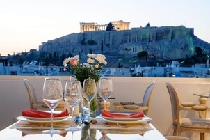 A table set for dining with a view of the Acropolis in Athens.