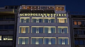 Acropolis-hotellin ulkoasu: valaistut kyltit, useita kerroksia ja selkeä sisäänkäynti, jonka edessä on ihmisiä.