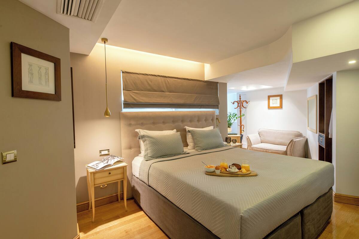 A neatly arranged bedroom with a bed, bedside table, and a chair.