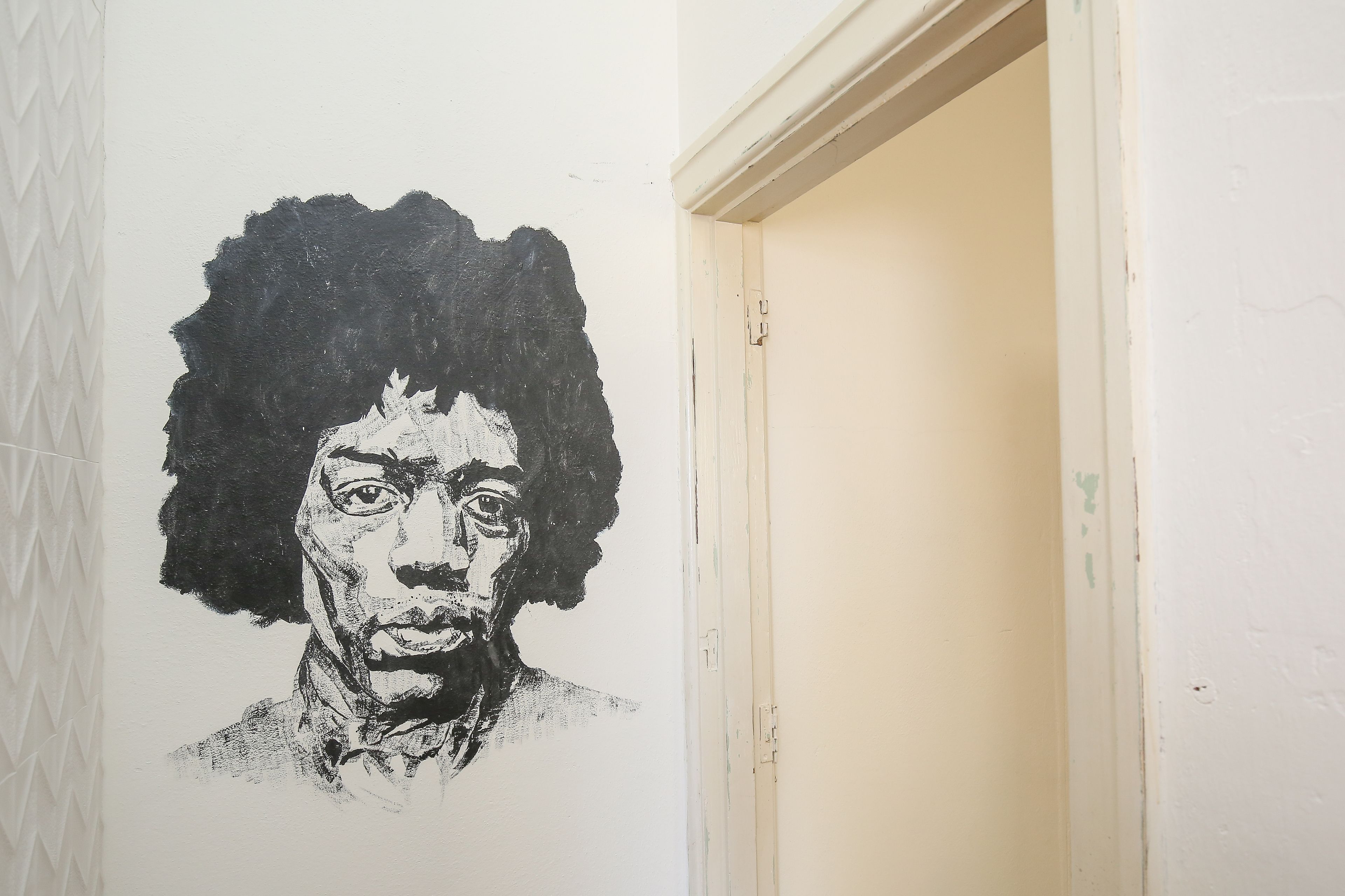 Un pasillo con una pared blanca que presenta un retrato en blanco y negro.