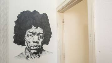 Un pasillo con una pared blanca que presenta un retrato en blanco y negro.