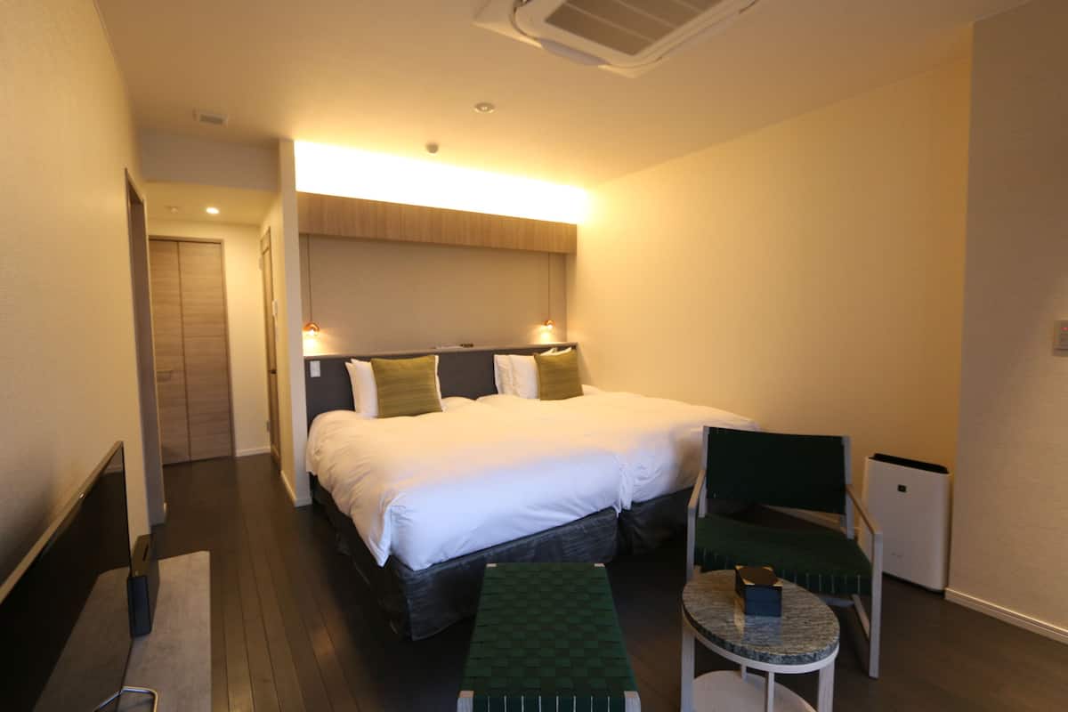 Ein Hotelzimmer mit Bett, Schreibtisch, Stuhl und kleinem Tisch.