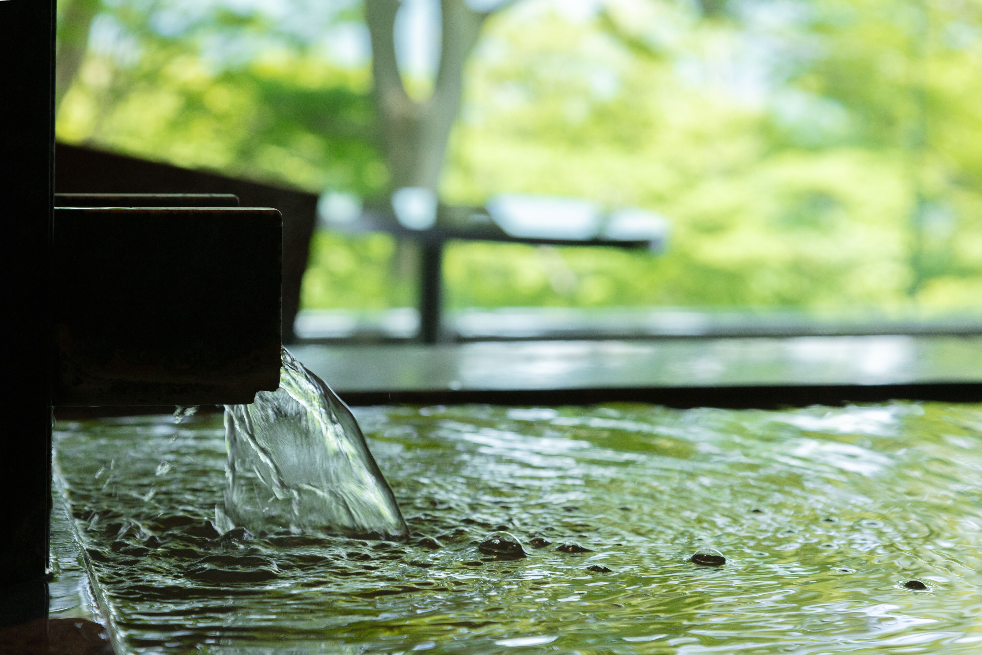 A water feature with a clear stream flowing over a textured surface.