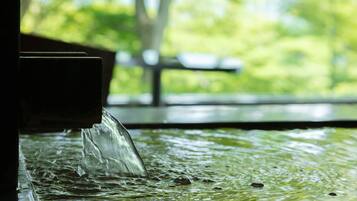 A water feature with a clear stream flowing over a textured surface.