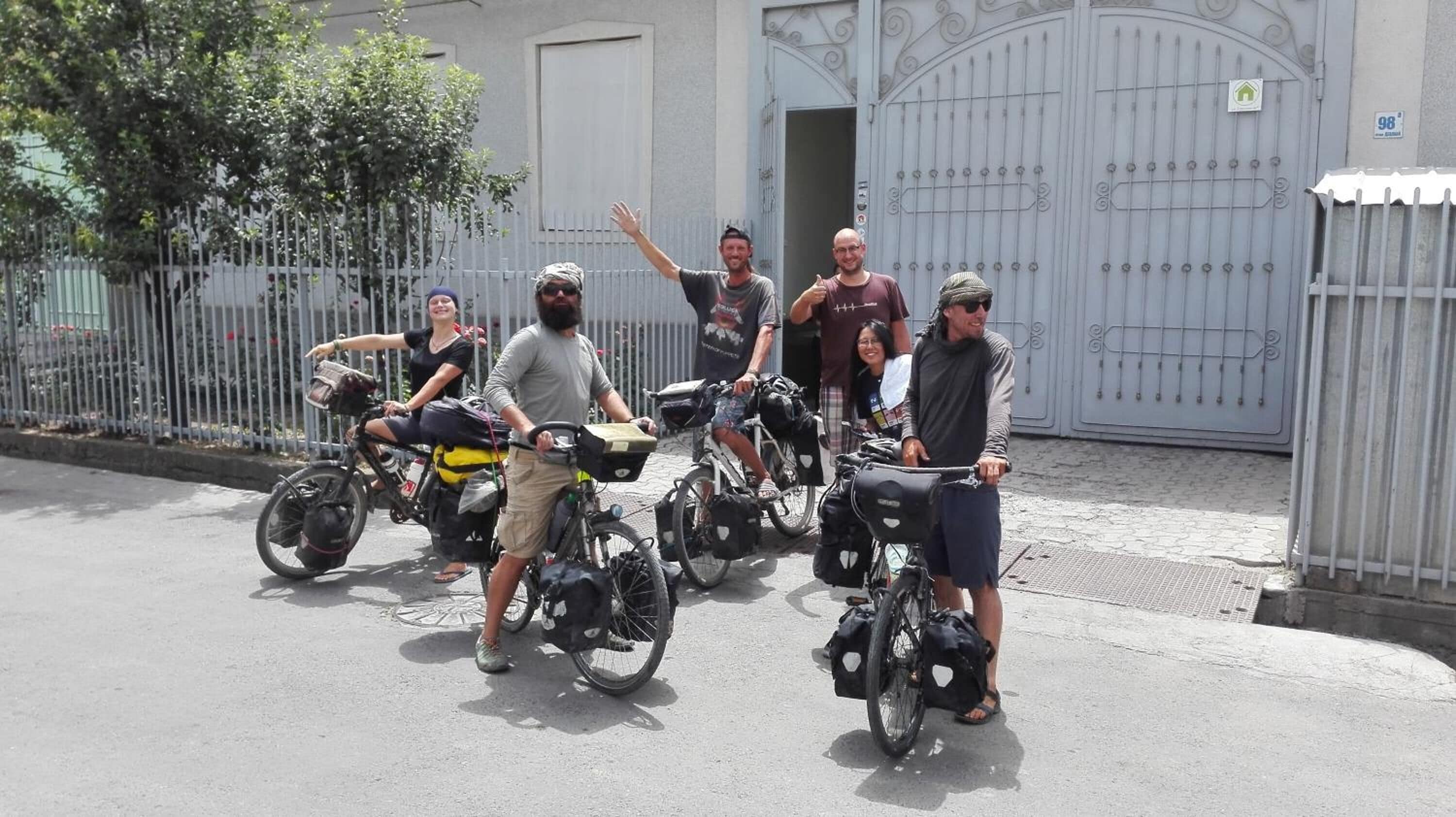 Un grup de persones amb bicicleta aparcades davant d'un edifici amb porta.