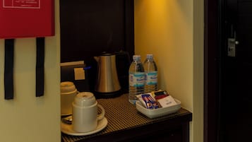 Une petite cuisine équipée d’une couverture anti-feu, de bouteilles d’eau, d’une machine à café et d’un service à thé.