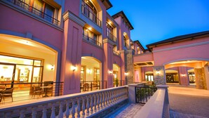 A multi-story hotel with outdoor seating and a stone facade. - Mestil Hotels & Residences (Kampala)