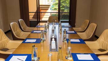 A conference room with a long table, chairs, and various items like bottles and papers.