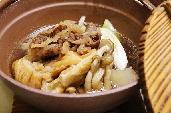 A bowl of soup with meat and vegetables.