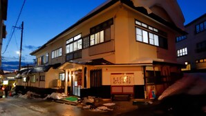 A two-story building with a balcony and a snow-covered roof. - Takasagoya Ryokan (Yamagata)