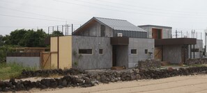 Una casa moderna de dos pisos con fachada de piedra, ventanas grandes y techo inclinado.