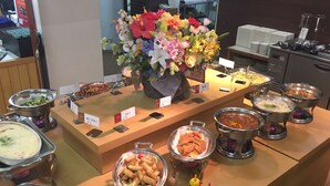 A buffet setup with various food items and a floral centerpiece. - Itoen Hotel Bekkan (Ito)