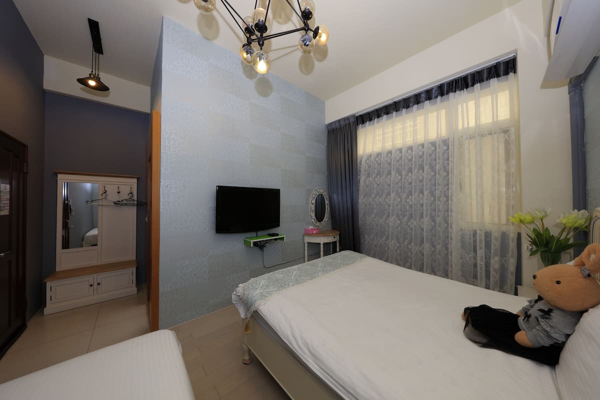 Ein Schlafzimmer mit Bett, Fernseher, Kleiderschrank und Spiegel.