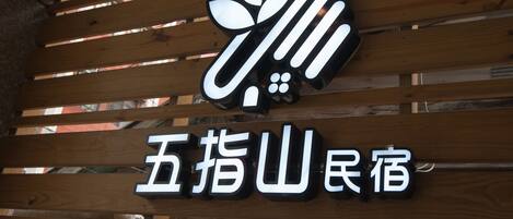 A wooden slatted ceiling with a sign featuring Chinese characters and a stylized logo.