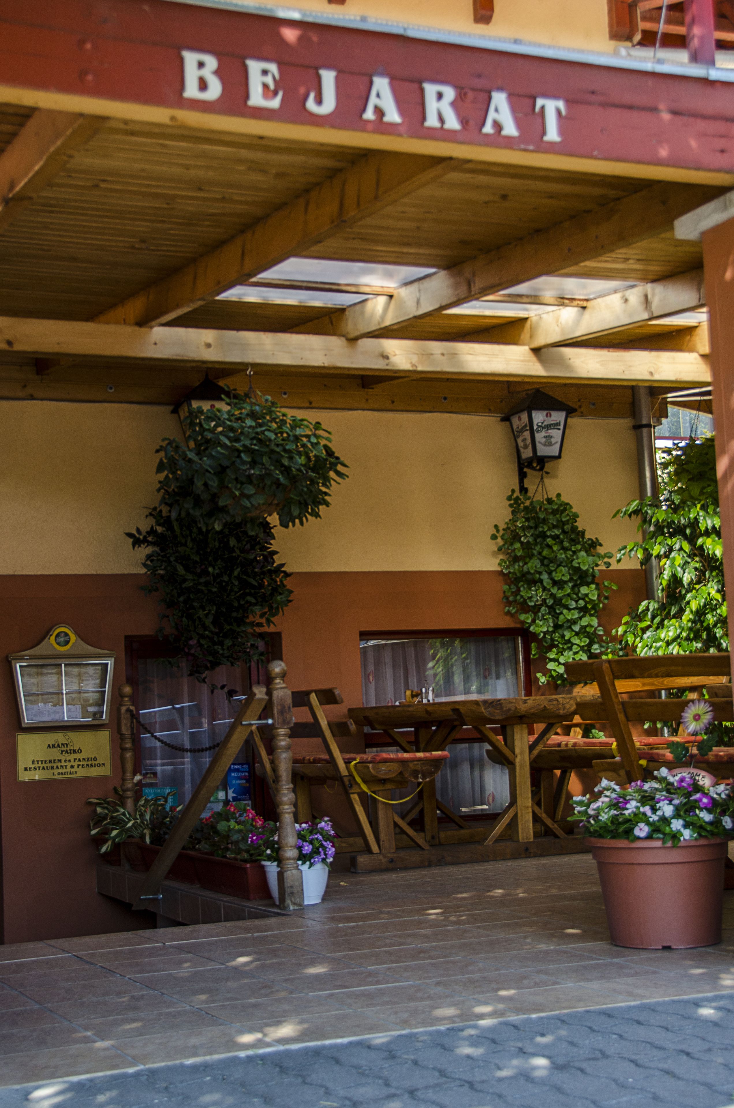 A wooden outdoor seating area with a sign reading "BEJARAT".