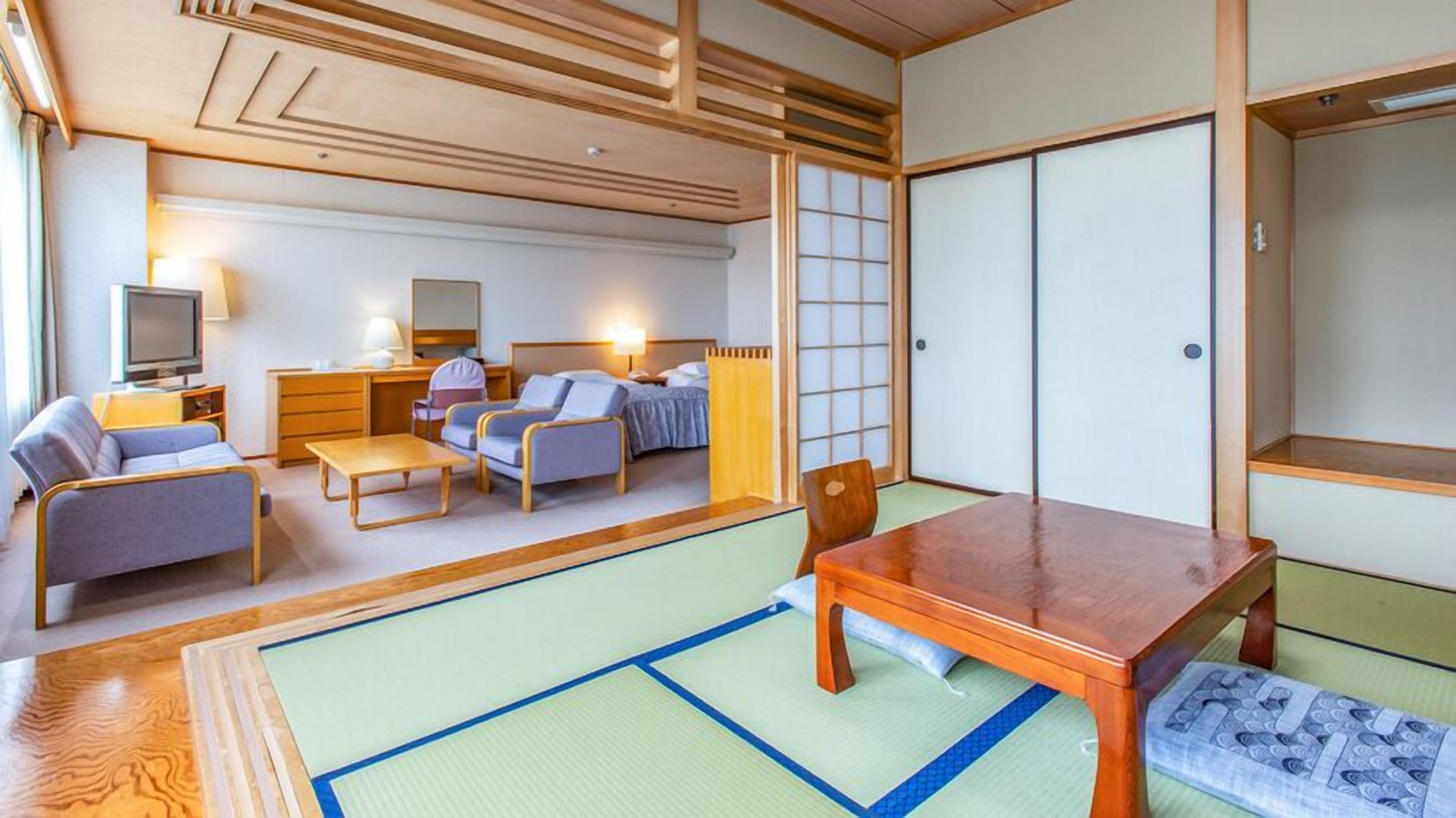 A traditional Japanese-style room with tatami flooring, a low wooden table, and a futon bed.