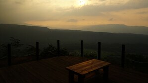 Um deck de madeira com um banco de observação para uma paisagem montanhosa.
