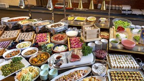 Um buffet com diversos alimentos e utensílios.