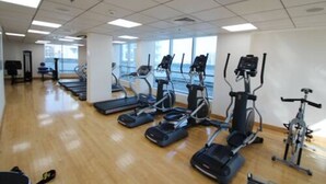 A gym with treadmills, elliptical machines, and stationary bikes arranged in rows. - Maison Privee - Stunning Apartment w/ Dubai Marina View (Dubai)