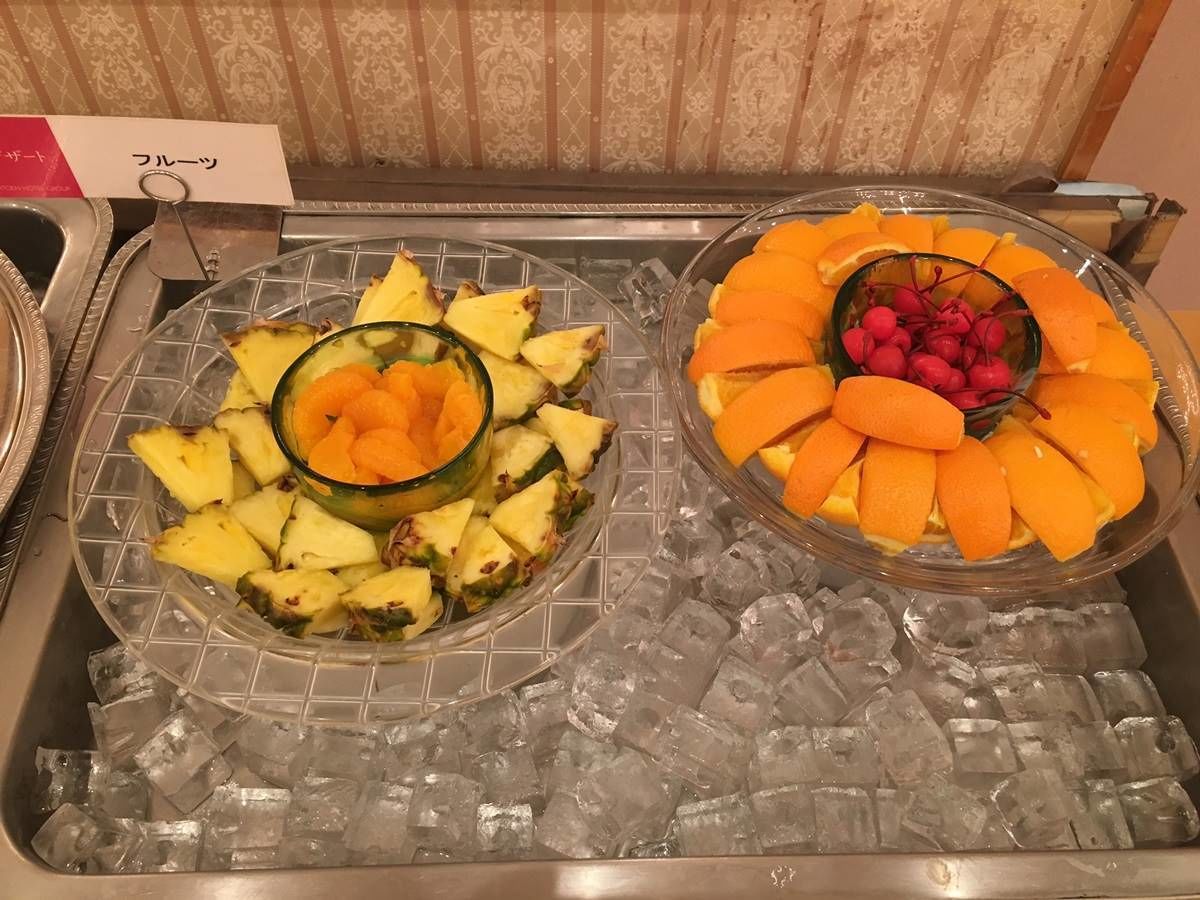 Dos tazones de fruta sobre una bandeja con cubitos de hielo.
