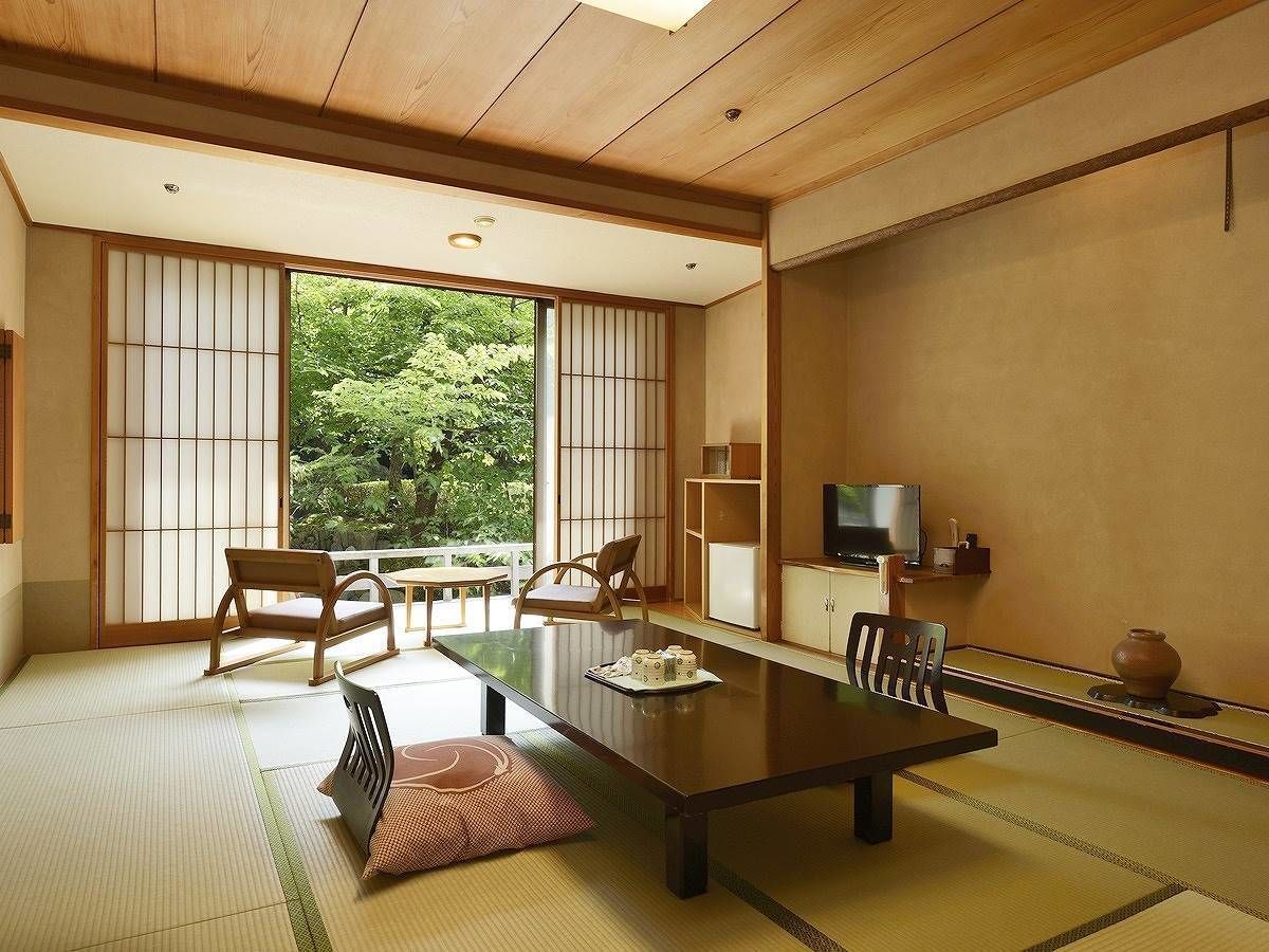 A traditional Japanese-style room with tatami flooring, a low table, and sliding doors.