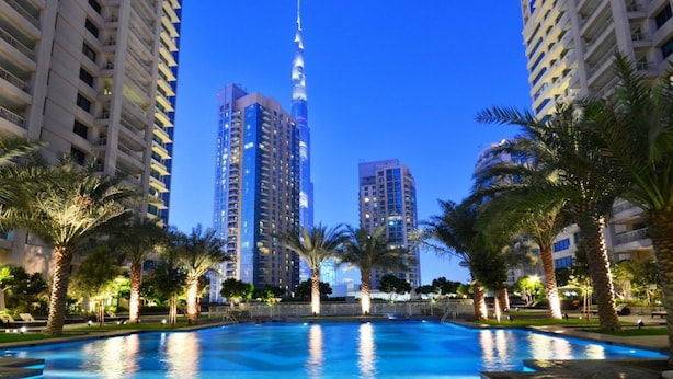 A pool area with tall buildings in the background. - Maison Privee - Radiant Urban Retreat with Iconic Burj Khalifa Vws (Dubai)