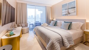 Habitación de hotel moderna con una cama grande, un escritorio, una silla y vistas a la ciudad a través de amplias ventanas.