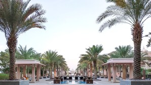 A pool area with palm trees, a gazebo, and a fountain. - Maison Privee - Charming Apt with Arabesque Sea View on the Palm Jumeirah (Dubai)