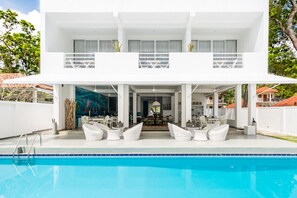 Een buitenzwembad, parasols bij het zwembad en ligstoelen