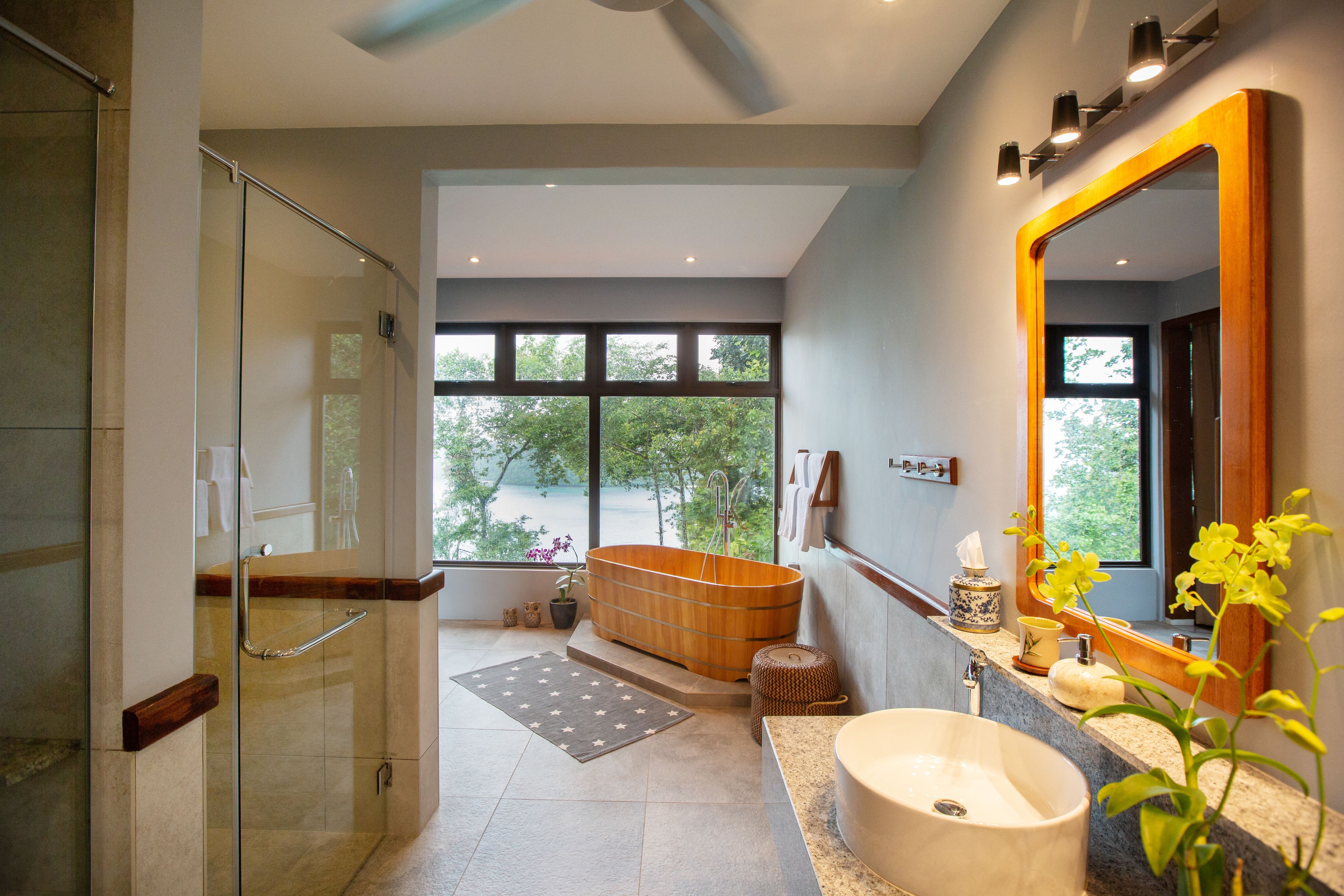 Une salle de bain moderne avec une douche en verre, une grande baignoire et un lavabo avec un miroir.
