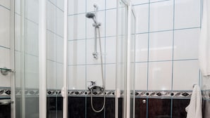 A bathroom with a glass-enclosed shower, a toilet, and a sink. - Istanbul Hotel (Tbilisi)