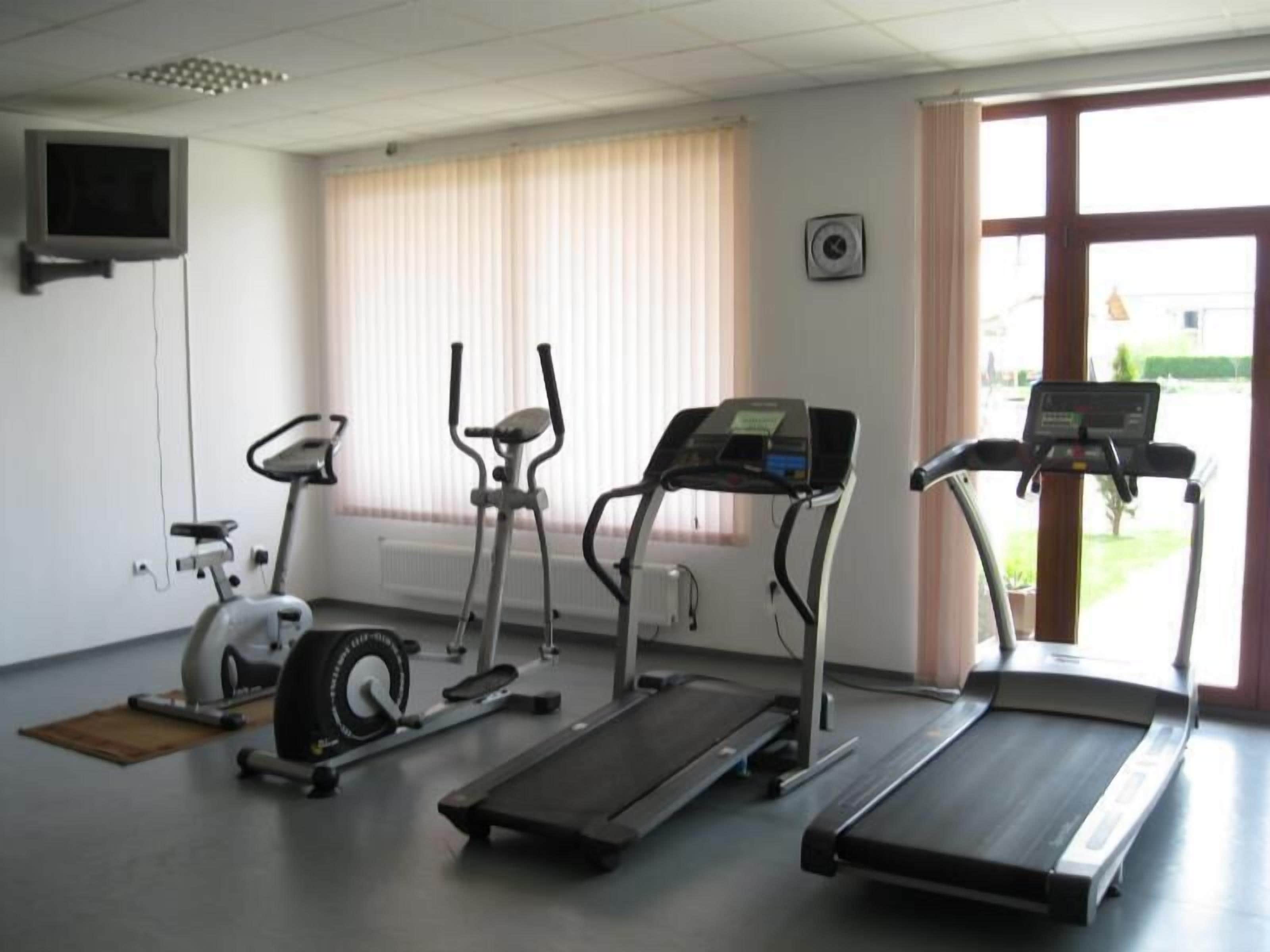 A fitness room with treadmills, an elliptical, and a stationary bike.