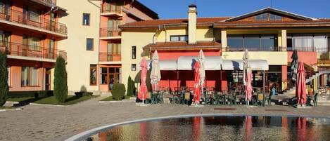 Un hotel con terraza y piscina.