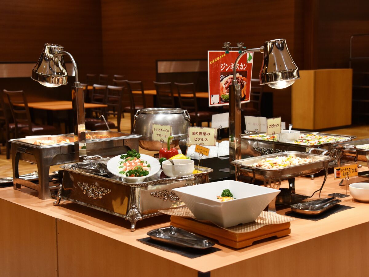 A buffet setup with various dishes and serving utensils.