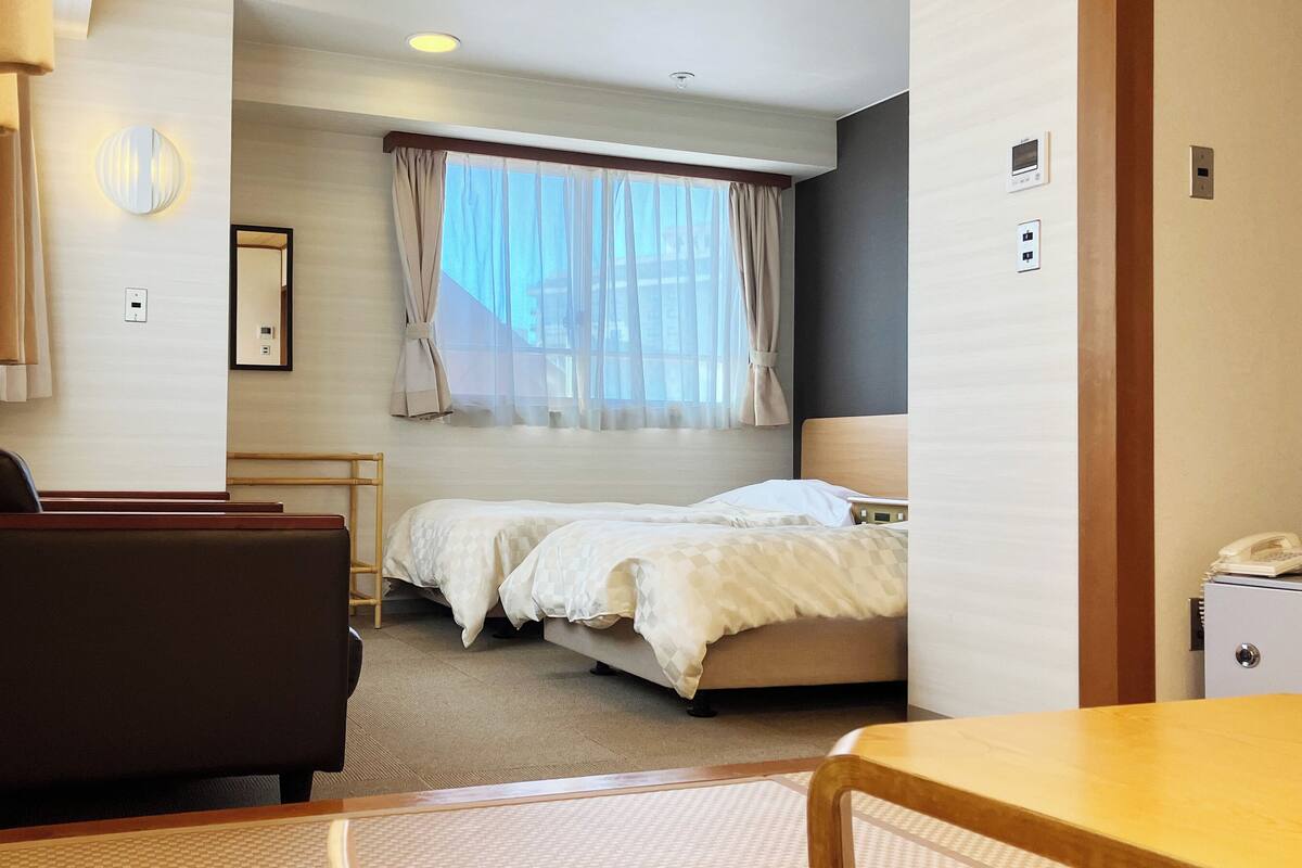 Une chambre d’hôtel avec un lit, un bureau, une chaise et une petite table.
