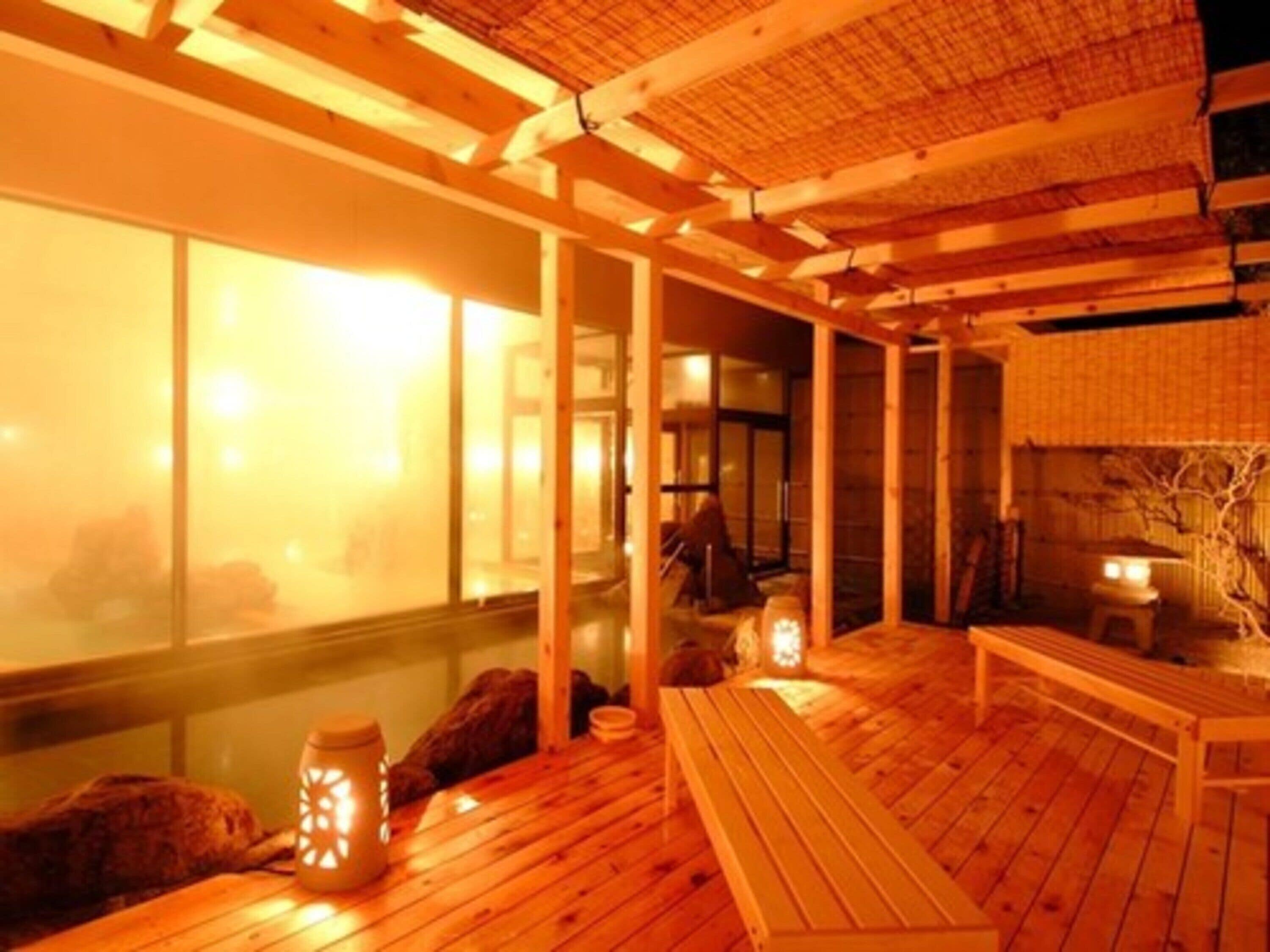 A traditional Japanese room with tatami flooring, wooden beams, and sliding doors.