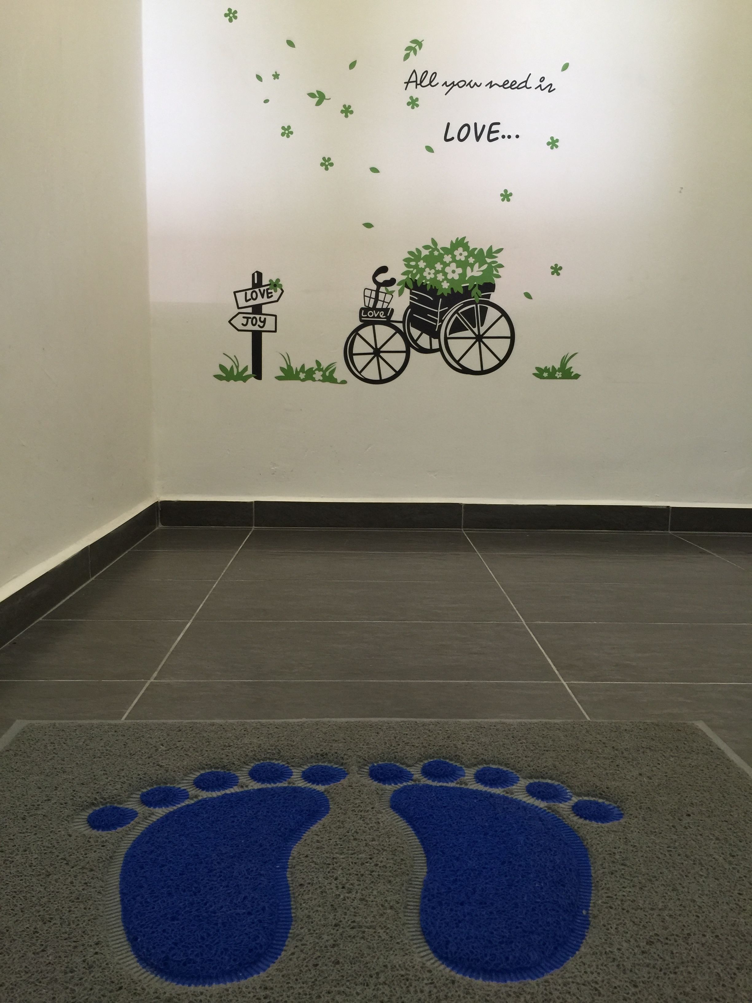 A room with a wall decorated with a love-themed design, including a bicycle with flowers and a sign that says "Love".
