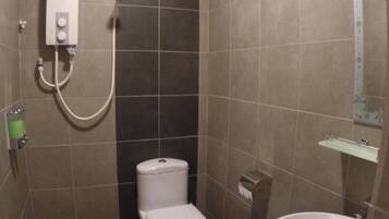 Un baño pequeño con azulejos, un inodoro, un bidé y un lavabo.