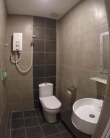 A small, tiled bathroom with a toilet, bidet, and sink.