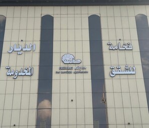 Een gevel met verschillende borden in Arabisch en Engels.