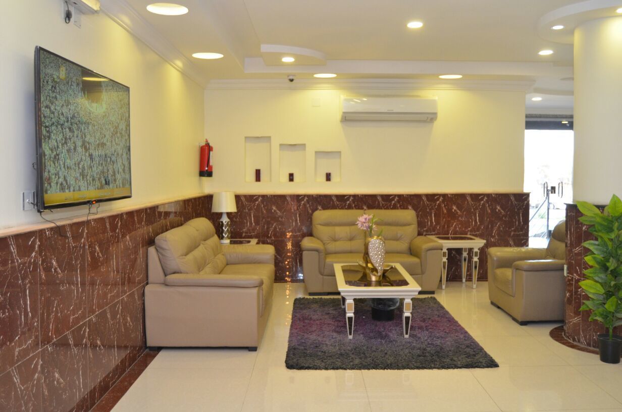 A modern living room with beige sofas, a coffee table, and a large abstract painting on the wall.
