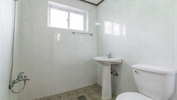 Une salle de bain avec une douche, un lavabo et des toilettes.