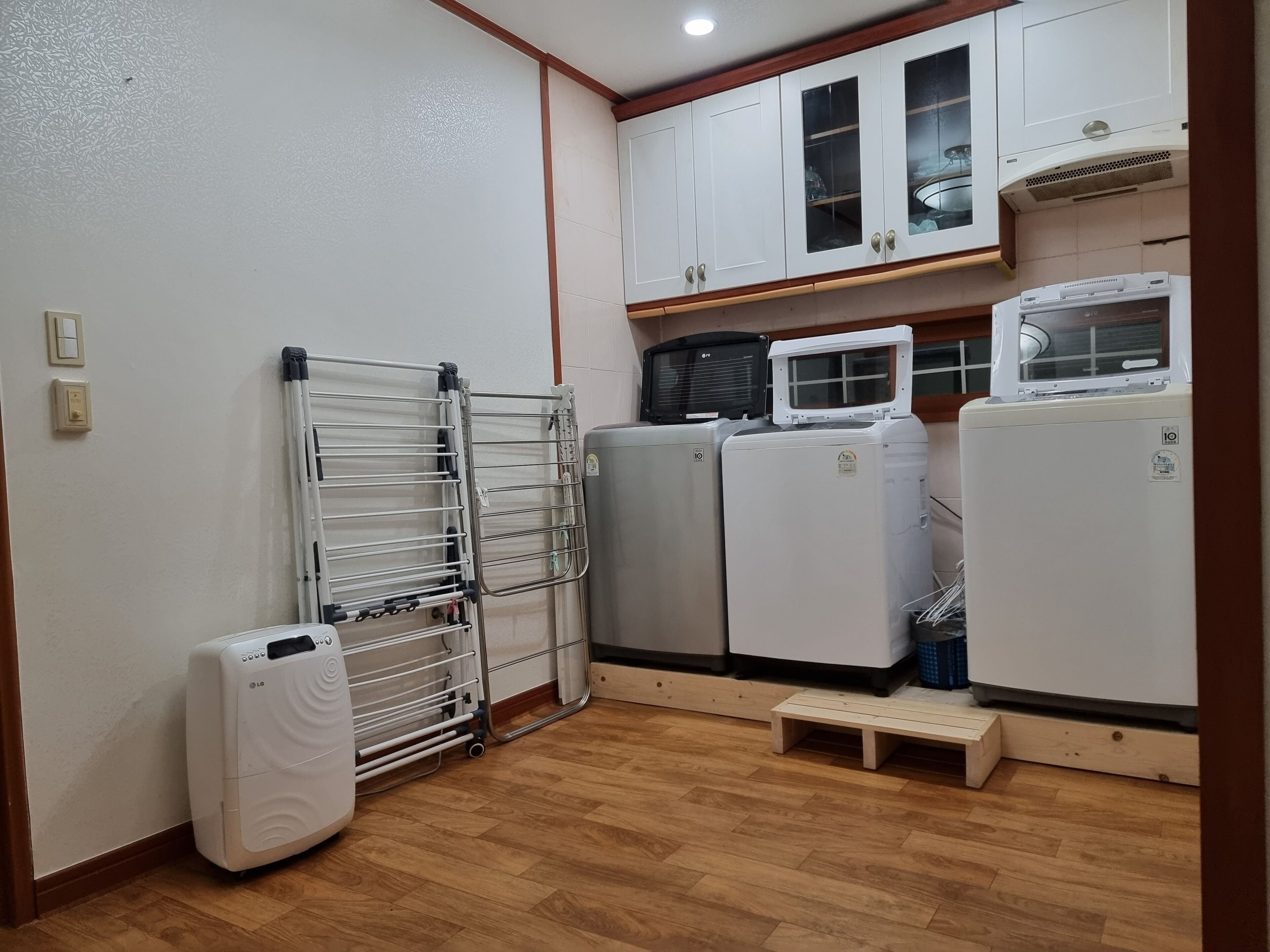 Una cocina compacta con armarios blancos, un microondas integrado y un refrigerador.
