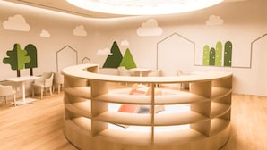A modern, circular reception desk with a spiral design, surrounded by white chairs and tables. - Incheon Airport Transit Hotel - Terminal 2 (Incheon)