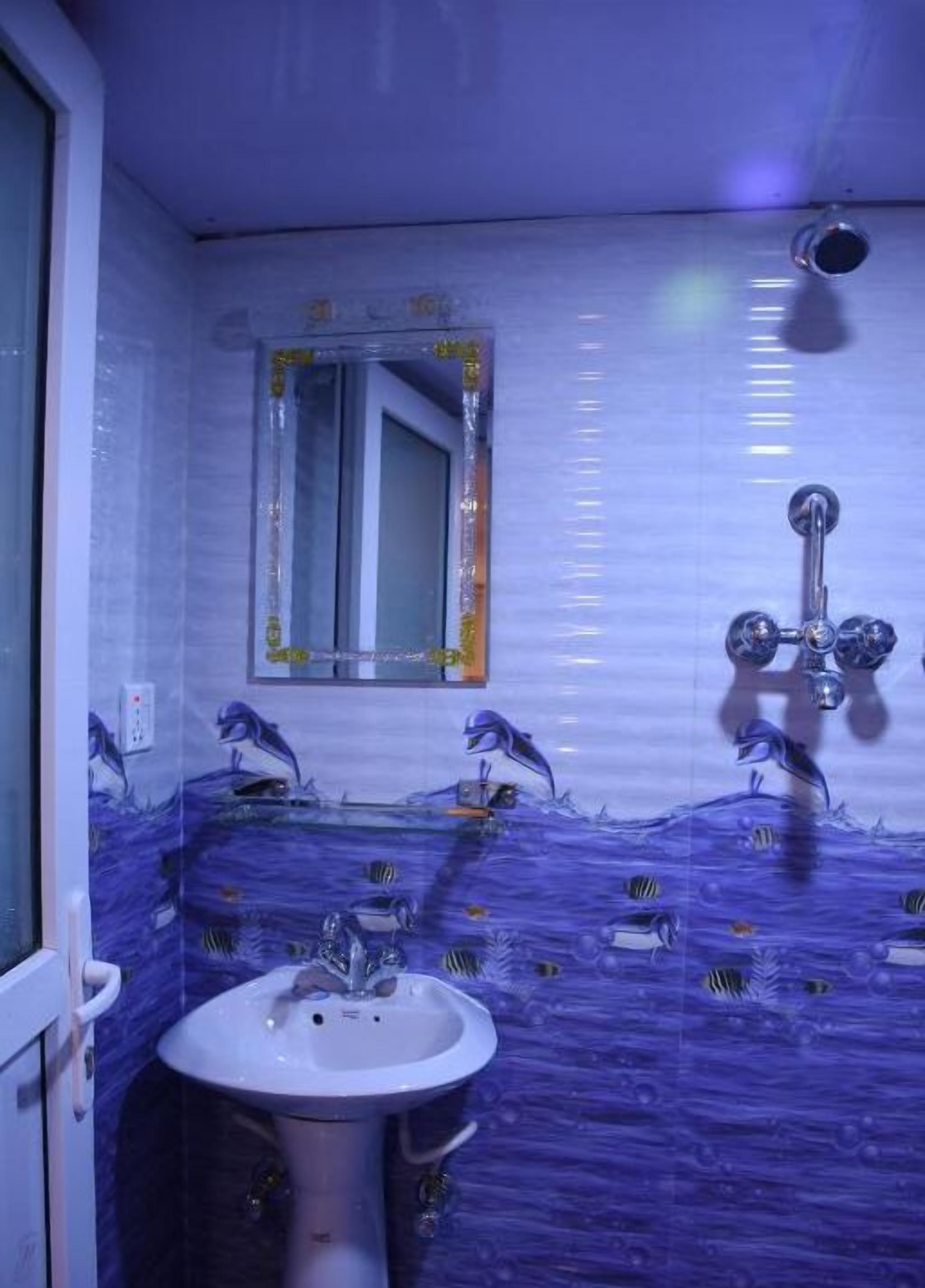 A bathroom with a sink, mirror, and shower.