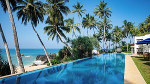 A pool with a view of the ocean and palm trees. - Kumu Beach (Balapitiya)