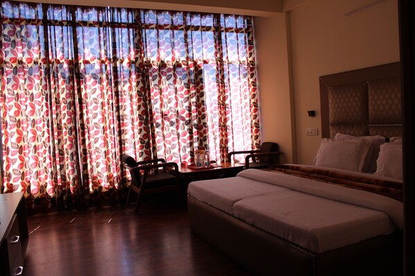 A hotel room with a bed, a desk, and a chair. - Hotel President (Dalhousie)