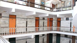 A multi-level hotel interior with a central atrium, balconies, and a modern design. - Hotel President (Dalhousie)